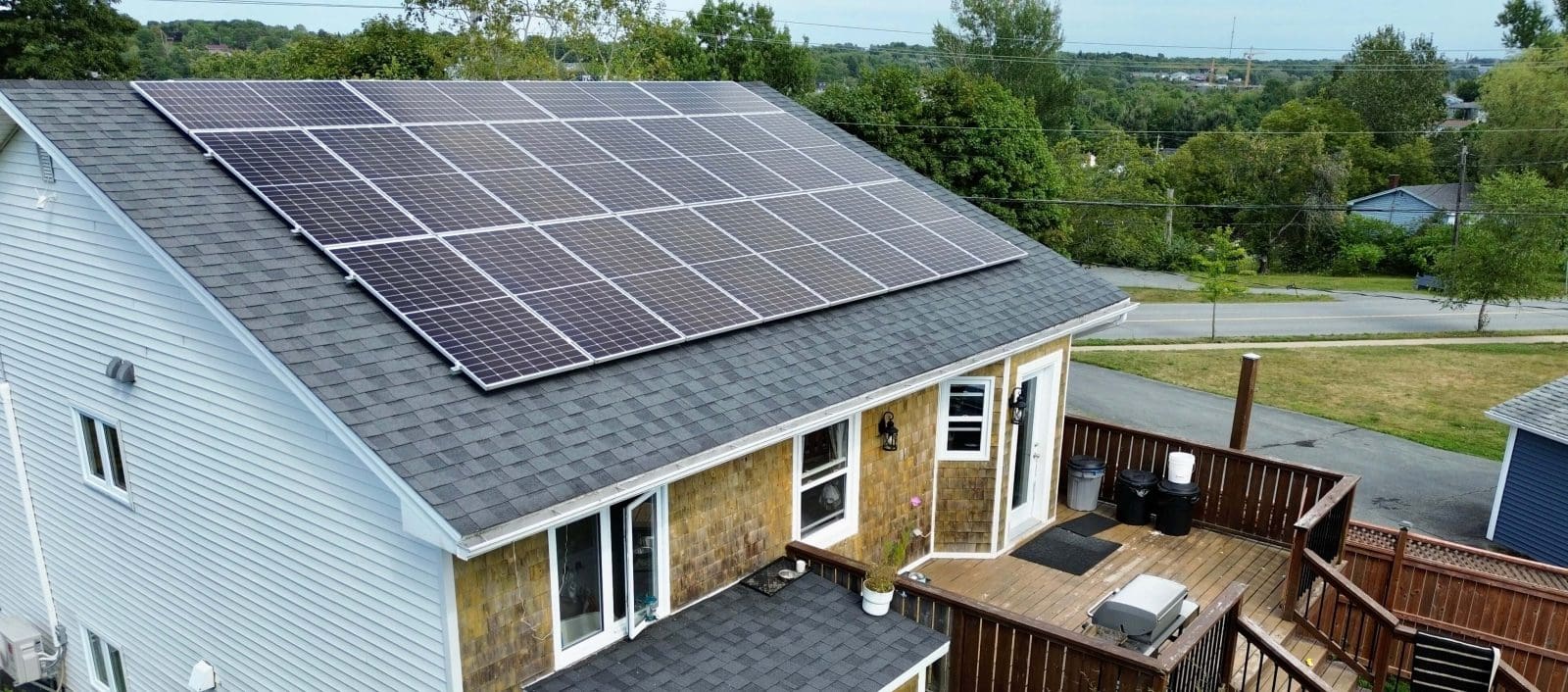 Backyard view of a home with solar panels on the roof.