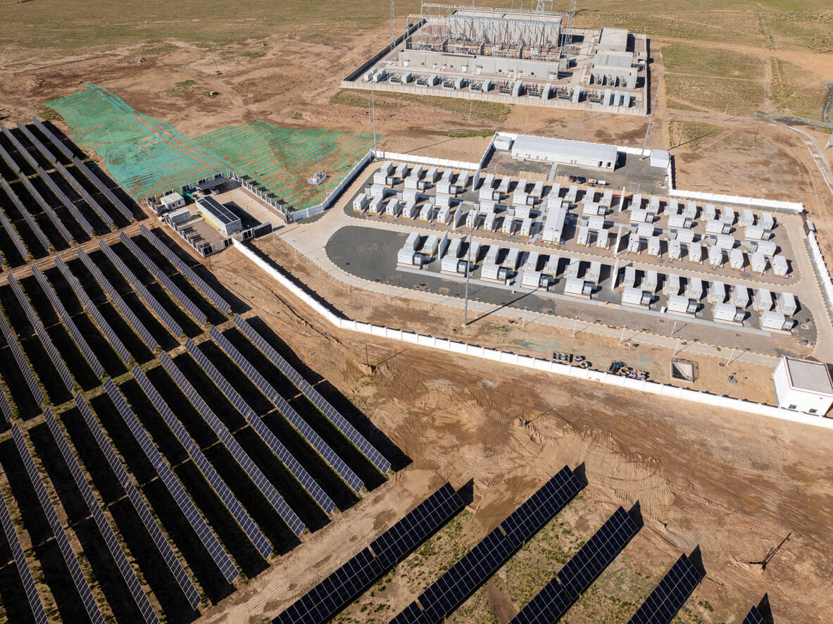 Aerial view of a microgrid with a large ground-mount solar farm beside it.