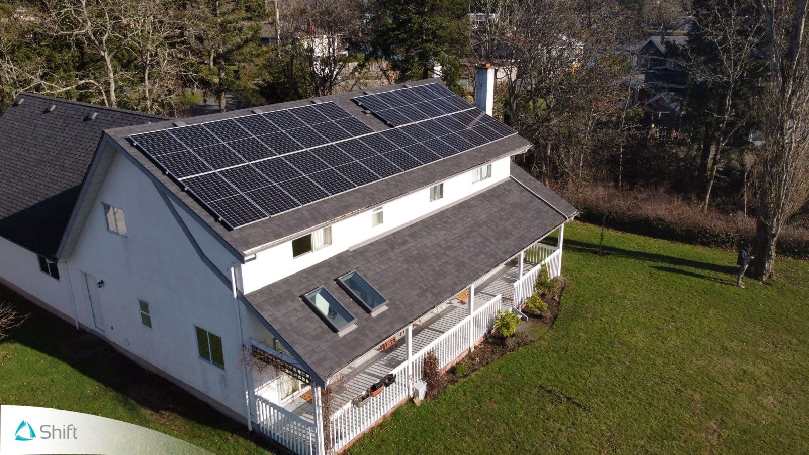 Side view of a home with a large solar panel installation on the roof.