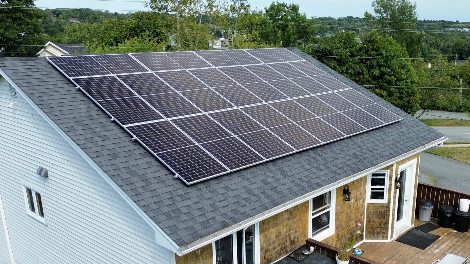 a side-angle view of a home with solar panels on the roof.