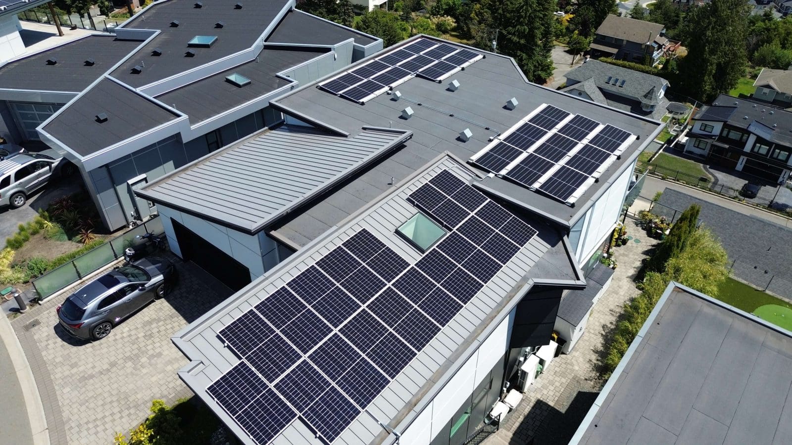 Aerial view of a home with multiple solar arrays on the roof.