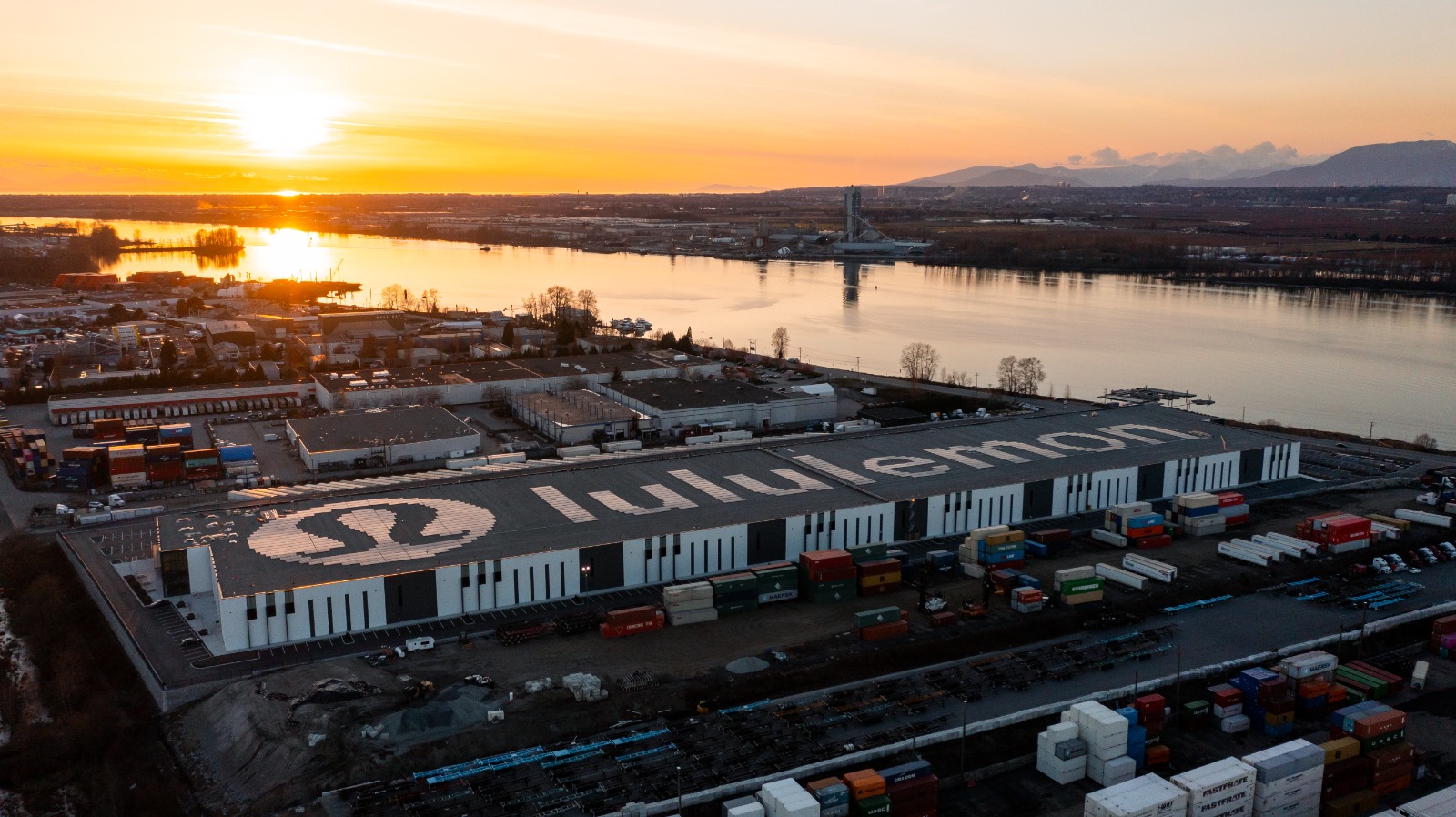 Aerial view of a commercial building with solar panels on the roof. The panels are installed to spell out the name Lululemon and the logo.